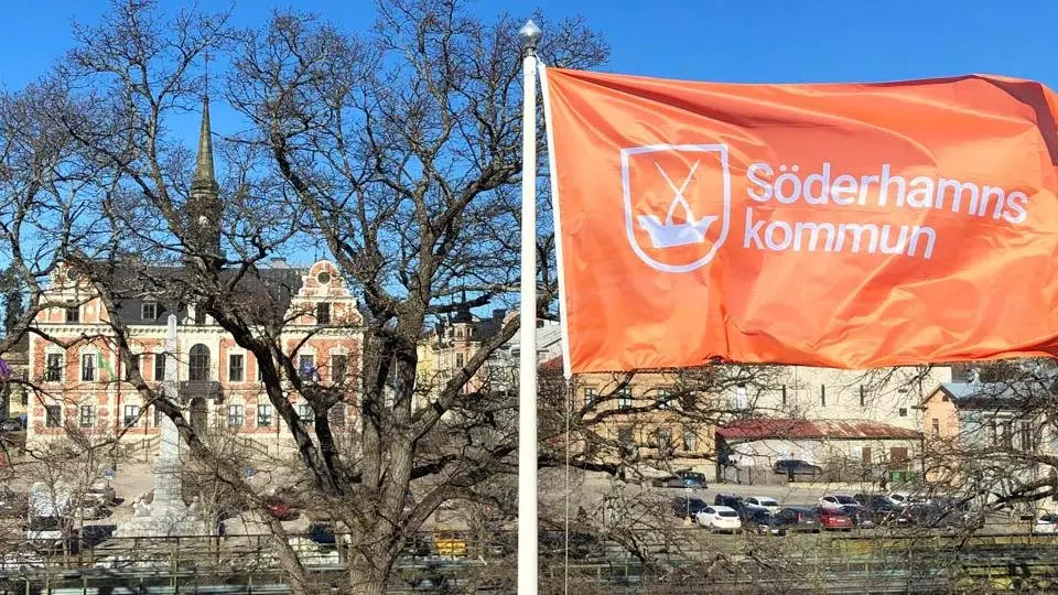 Söderhamns kommun-flagga i förgrunden och Rådhuset i bakgrunden.