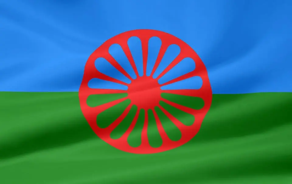 Romernas flagga, rött hjul på blå och grön bakgrund.
